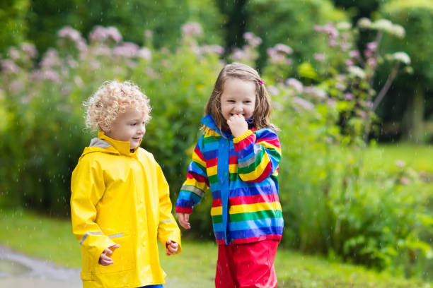 istock Kids play in rain and puddle in autumn 675011046