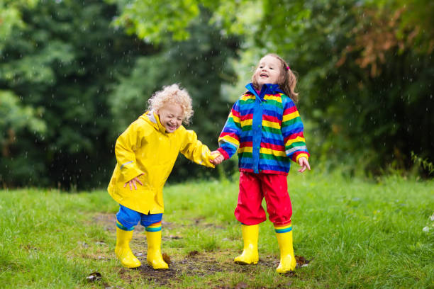 istock Kids play in rain and puddle in autumn 675011118