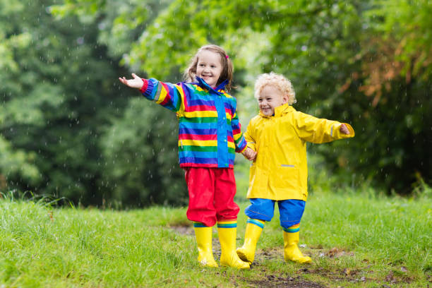 istock Kids play in rain and puddle in autumn 675011242