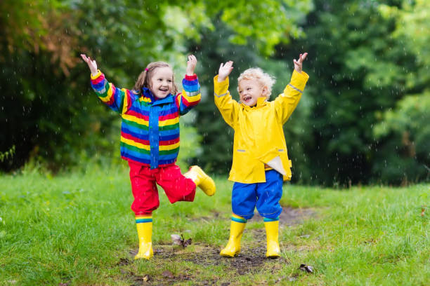 istock Kids play in rain and puddle in autumn 675011330