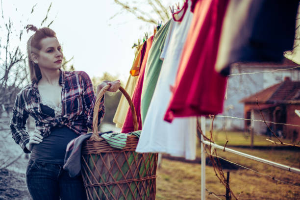 bella donna in stile vintage che fa il bucato nel cortile sul retro della casa - hair bow shirt bow one young woman only foto e immagini stock