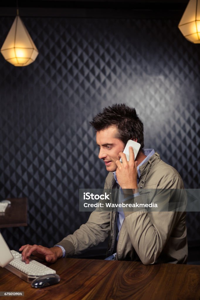 Creative businessman using smartphone Creative businessman using smartphone in office Animal Call Stock Photo