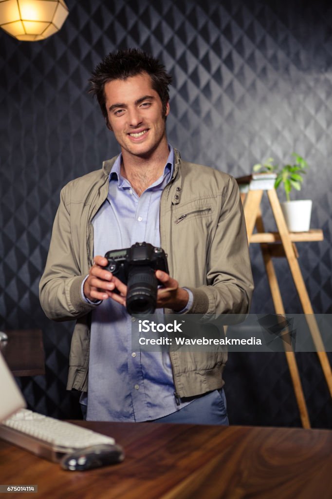 Creative businessman looking at picture on camera Creative businessman looking at picture on camera in office 20-24 Years Stock Photo