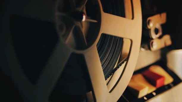 antiguo cine de 8 mm proyector jugando en la noche. primer plano de un carrete con una película - 8mm film projector fotografías e imágenes de stock