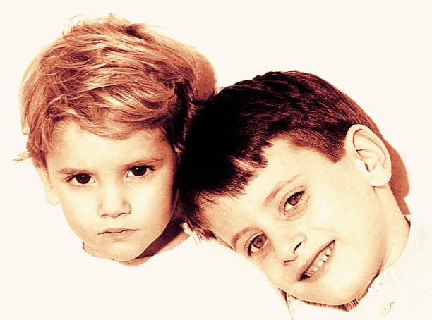 Sepia colored portrait of a cute couple of brothers looking at camera