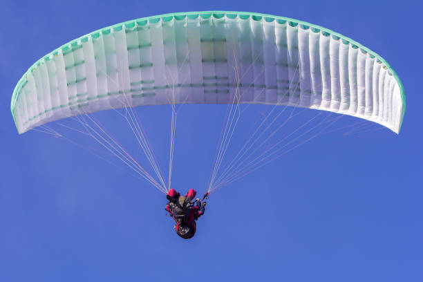 istock Paragliding in tandem free gliding and blue sky as background 675042010