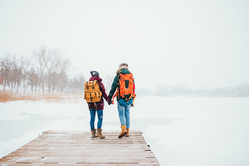 Young couple enjoying winter day on a frozen lake