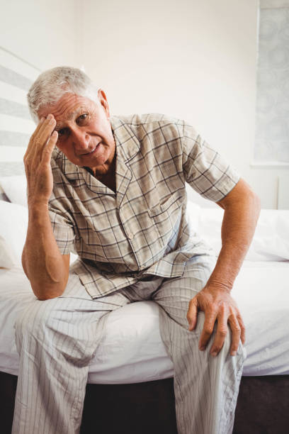 istock Frustrated senior man sitting on bed 675049294