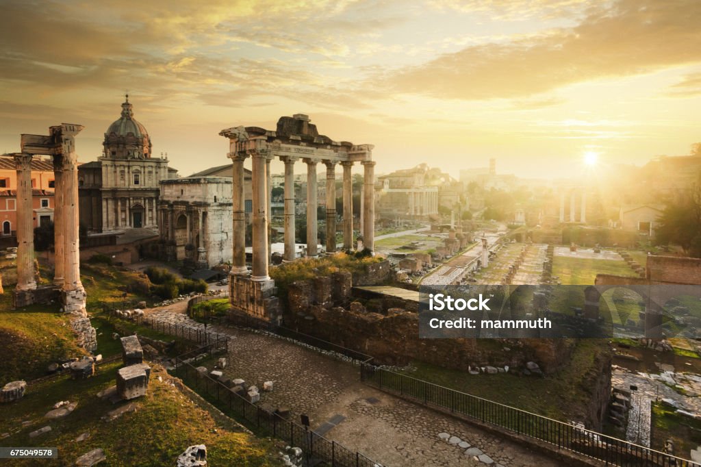 Roman Forum at sunrise, from left to right: Temple of Vespasian and Titus, church of Santi Luca e Martina, Septimius Severus Arch, ruins of Temple of Saturn. Ancient ruins in Rome, Lazio, Italy Ancient Rome Stock Photo