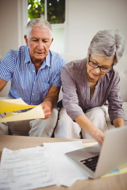 istock Senior woman paying bills online on laptop 675052336