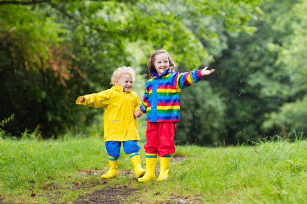 istock Kids play in rain and puddle in autumn 675052514