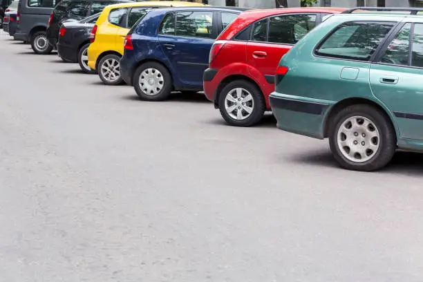 Photo of multicolored cars parked diagonally at parking lot in the street