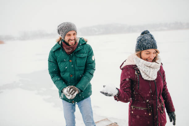 istock Young couple in a snowball fight 675058864