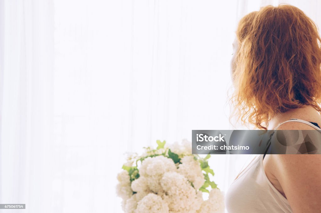 Young beautiful pregnant woman sitting near window at home Young woman sitting near window at home Adult Stock Photo