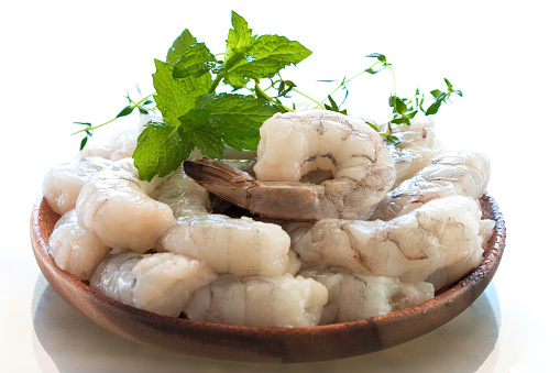 Raw shrimps in wooden plate.