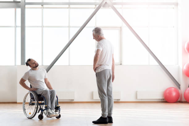 istock Attentive disabled man training in the gym with the orthopedist 675063132