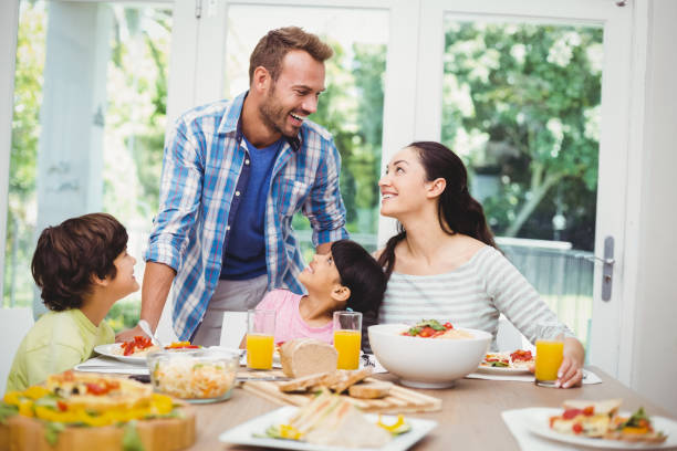 istock Smiling family discussing at dining table 675063148