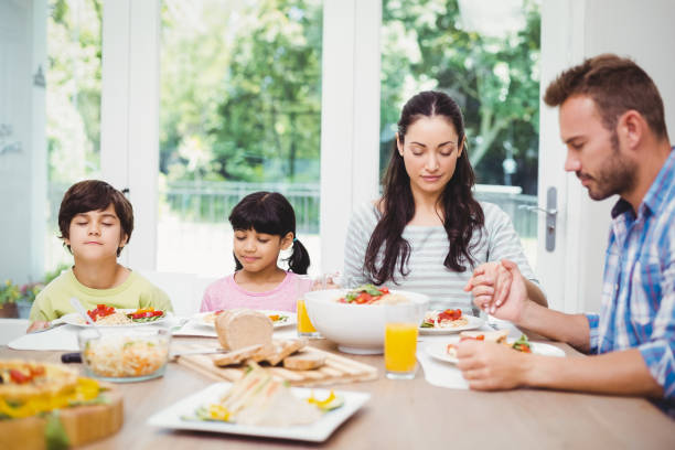 istock Family with eyes closed while sitting at dining table 675063258