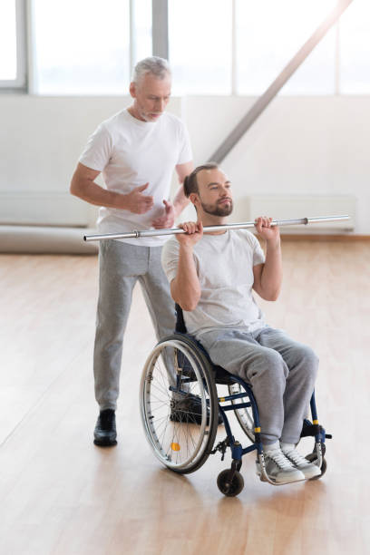 istock Involved aged physical therapist teaching the invalid in the gym 675063362