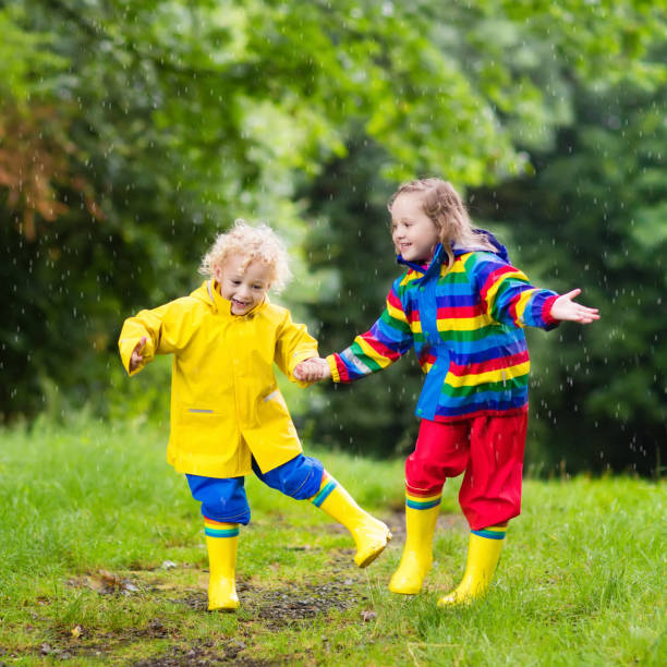 istock Kids play in rain and puddle in autumn 675063800