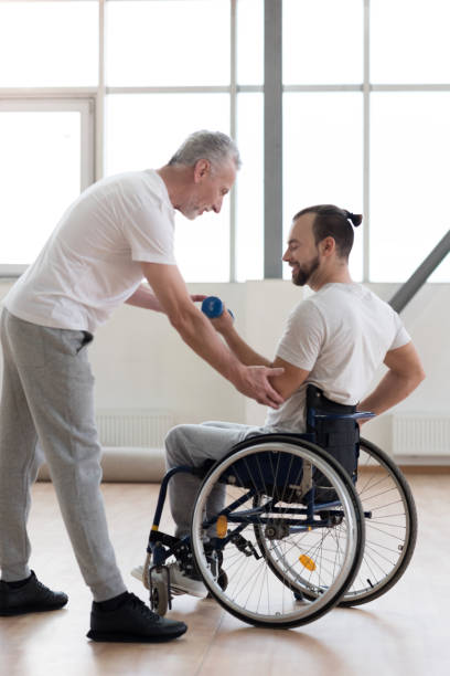 istock Cheerful disabled man exercising with his coach in the gym 675063828
