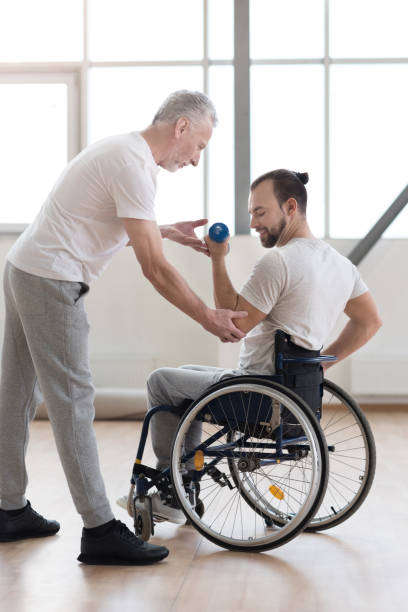 istock Confident disabled man exercising with his coach in the gym 675063858