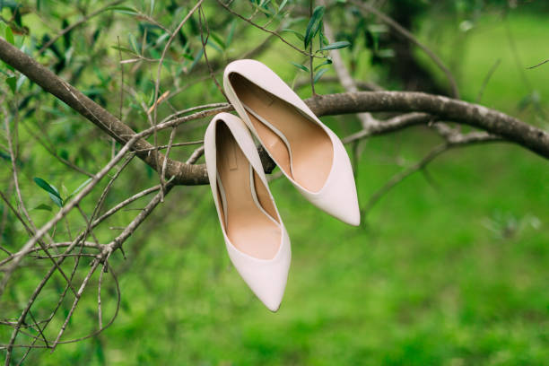 istock Light cream bride shoes hanging on a branch 675063972