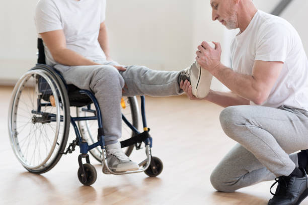 istock Aged orthopedist working with handicapped in the gym 675063996