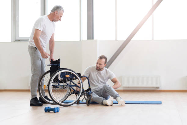 istock Involved orthopedist working with disabled patient in the gym 675064034