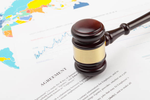 istock Wooden judge's gavel and calculator over some financial documents 675064160