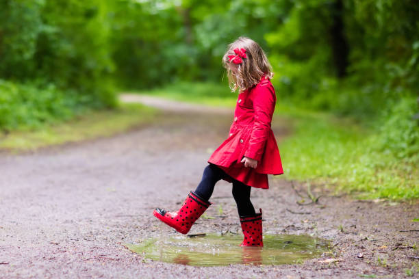 istock Little girl walking in the rain 675064582