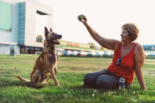 Portrait of senior woman in her early sixties, slightly overweight, enjoying her life and leisure time. Woman is expressing positivity and determination towards life goals. Wman is spending time with her dog