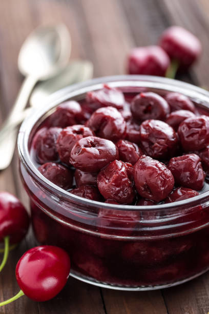 istock Berries cherry with syrup in a glass jar. Canned fruit 675072334