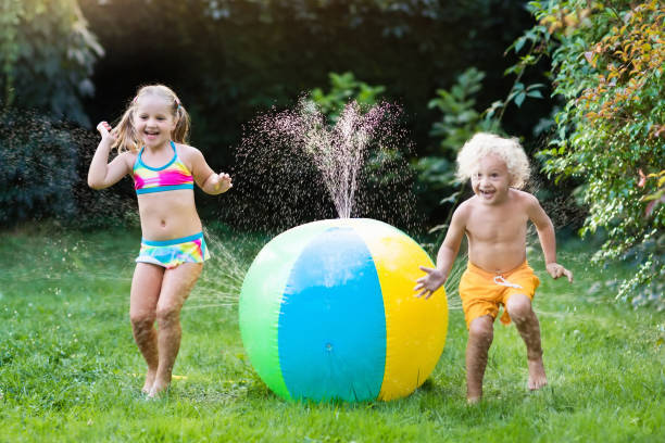 kinder spielen mit wasserball spielzeug sprinkler - 11880 stock-fotos und bilder