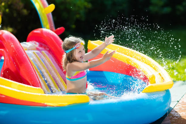 istock Child in garden swimming pool with slide 675074826