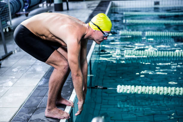 istock Fit swimmer about to dive into the swimming pool 675075030