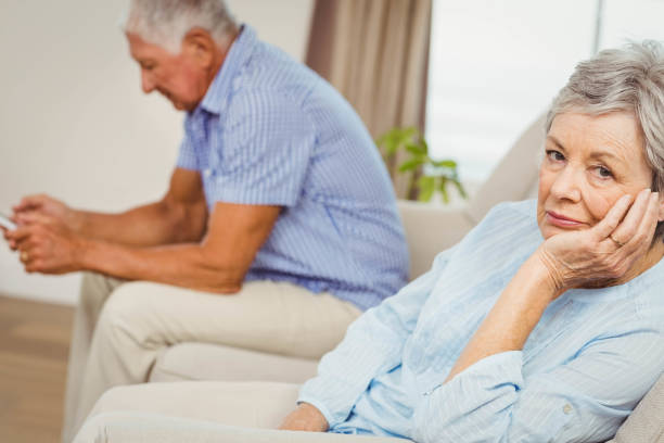 istock Worried senior woman sitting on sofa 675076462