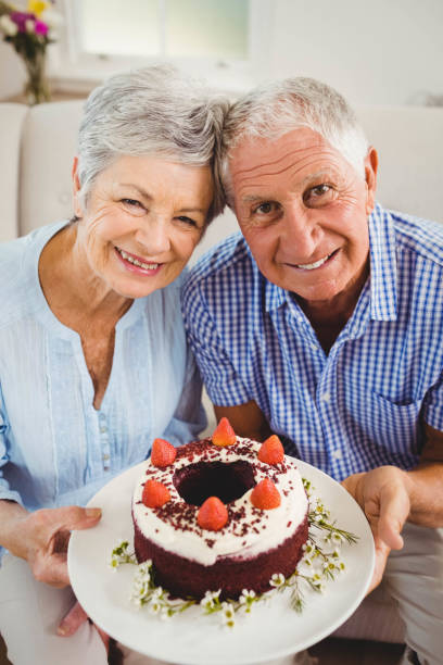 istock Senior couple holding a cake 675076740