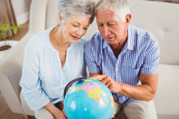 istock Senior couple looking at a globe 675076764