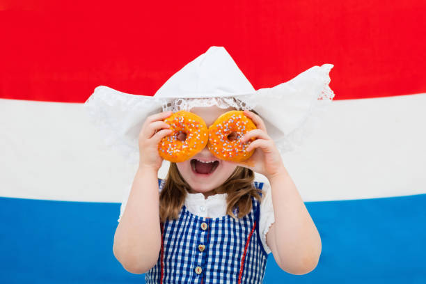 istock Dutch girl with orange donuts and Netherlands flag 675076836