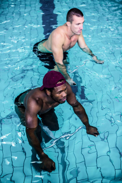 istock Fit men cycling in the pool 675076856