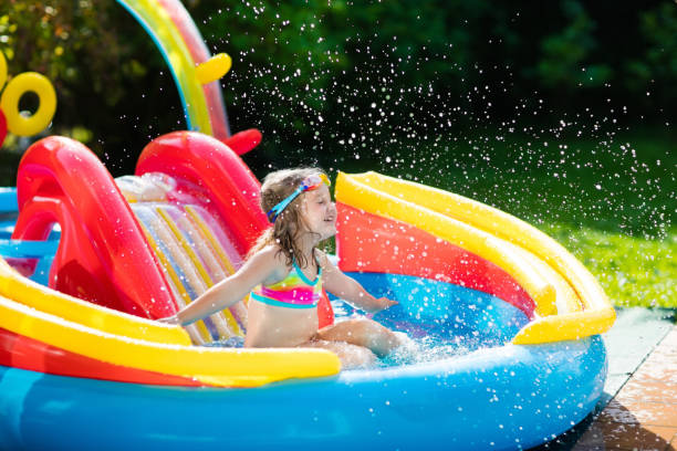 istock Child in garden swimming pool with slide 675077784