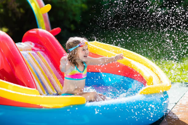 istock Child in garden swimming pool with slide 675078182