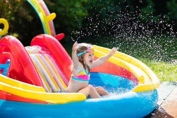 istock Child in garden swimming pool with slide 675079394