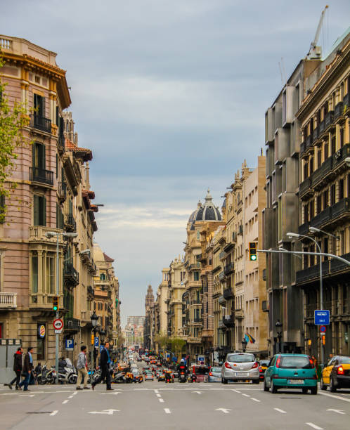 Barcelona, Spain, April 12, 2012: Street view with people crossing, and cars driving