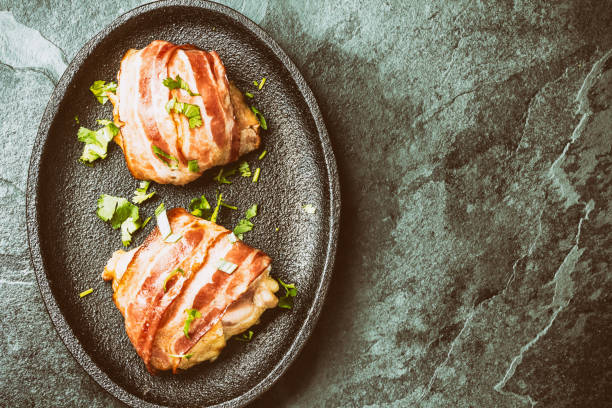istock Baked chicken wrapped in bacon on iron plate 675085430