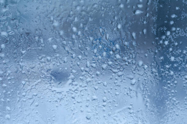 istock Rain drops and frozen water on window glass background 675085476