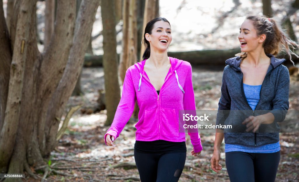 deux femmes se wlaking au milieu des bois - Photo de Marche rapide libre de droits