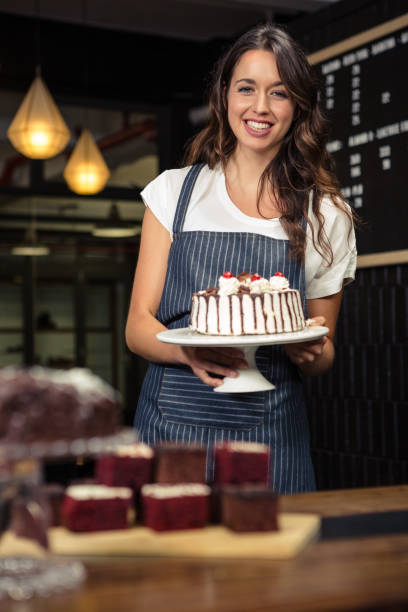 istock Smiling barista holding plate with cake 675089440