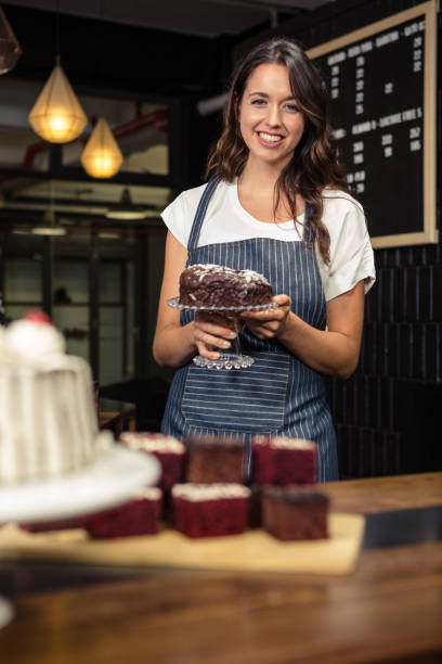 istock Smiling barista holding plate with cake 675089526